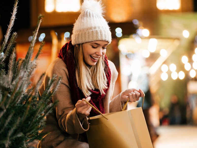 female christmas shopper looking in her shopping bag